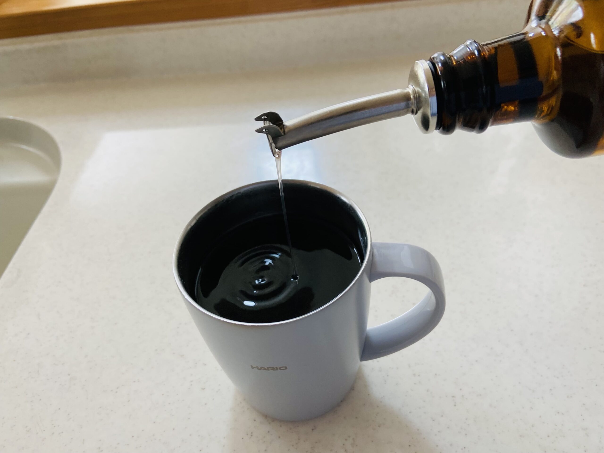 MCTオイルをボトルポアラーを使って使ってブラックコーヒーに入れる